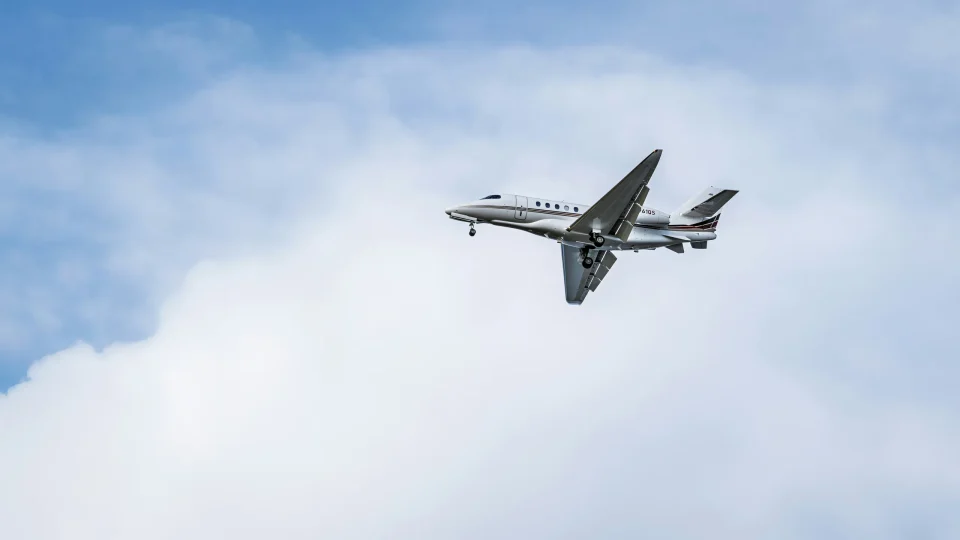 Private jet flying through a cloudy sky