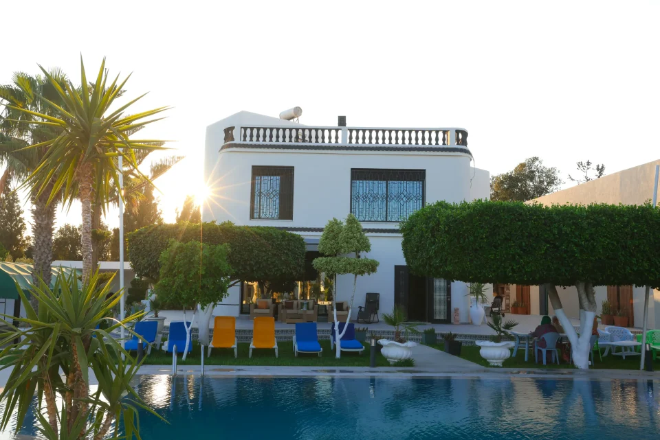 White villa and garden beside a swimming pool