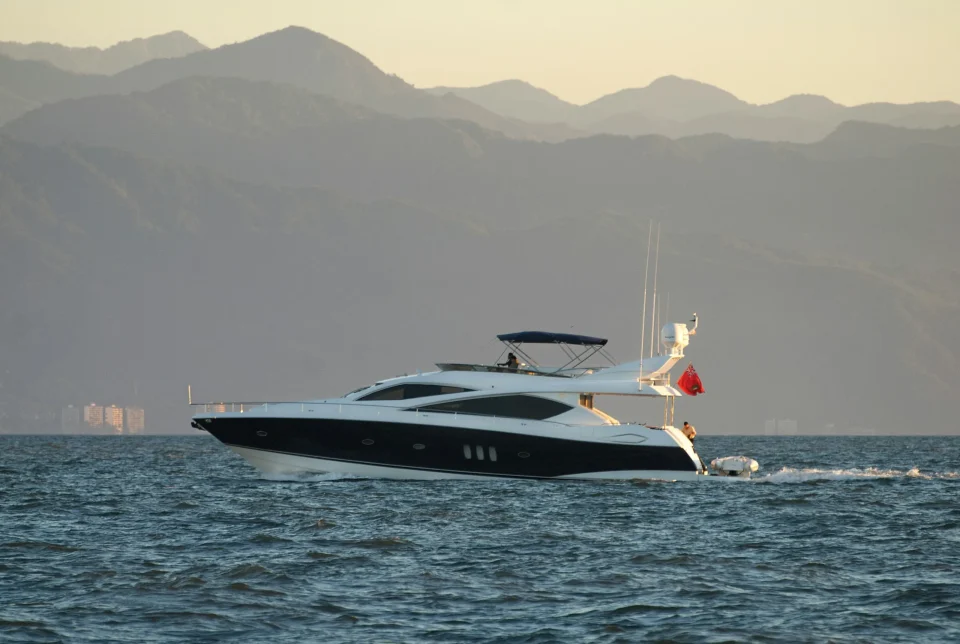 Motor yacht cruising with mountains behind